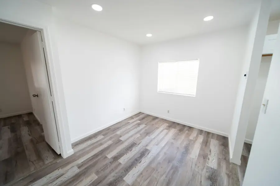 Freshly painted empty bedroom with wood-look flooring ready for a home inspection